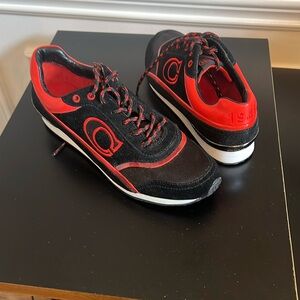 Black and Orange Coach tennis shoe with the number 1941 on back